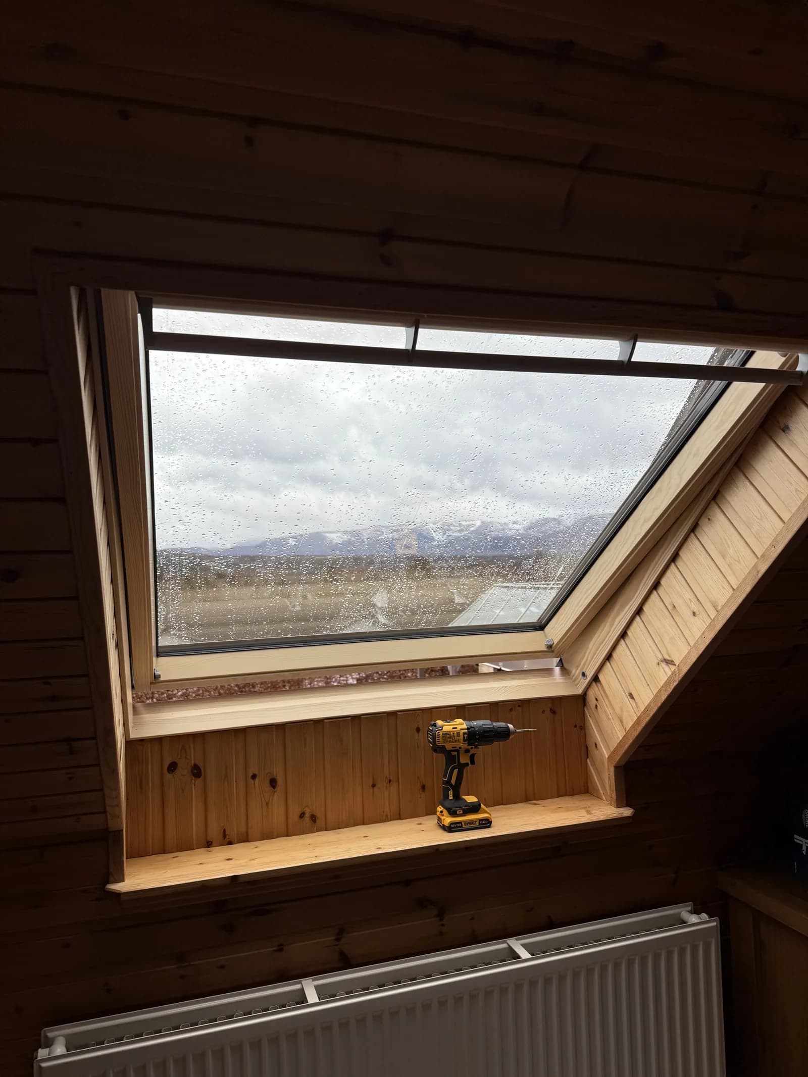 VELUX roof window in a timber-clad loft room