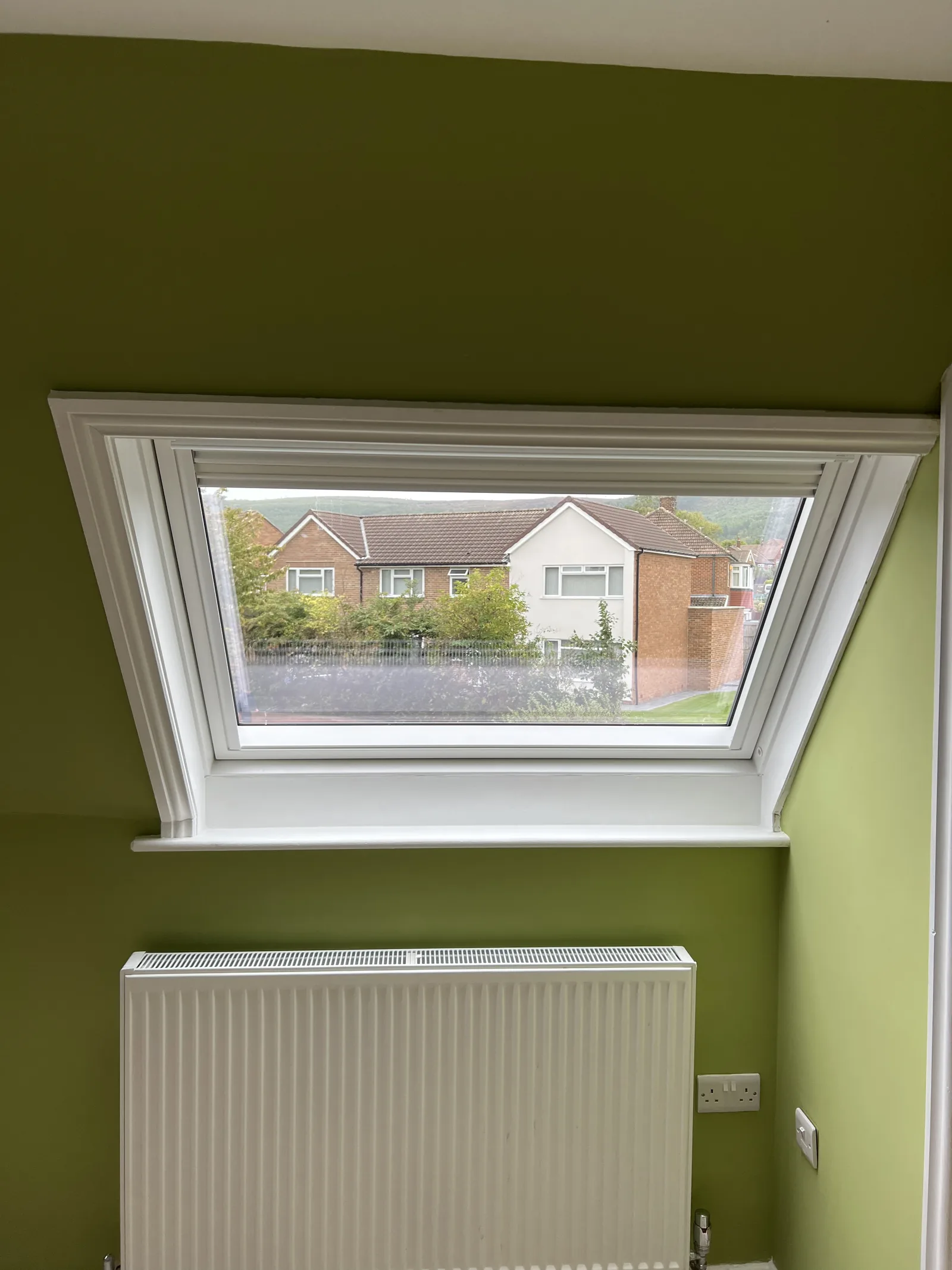 Roof window in a green-painted room