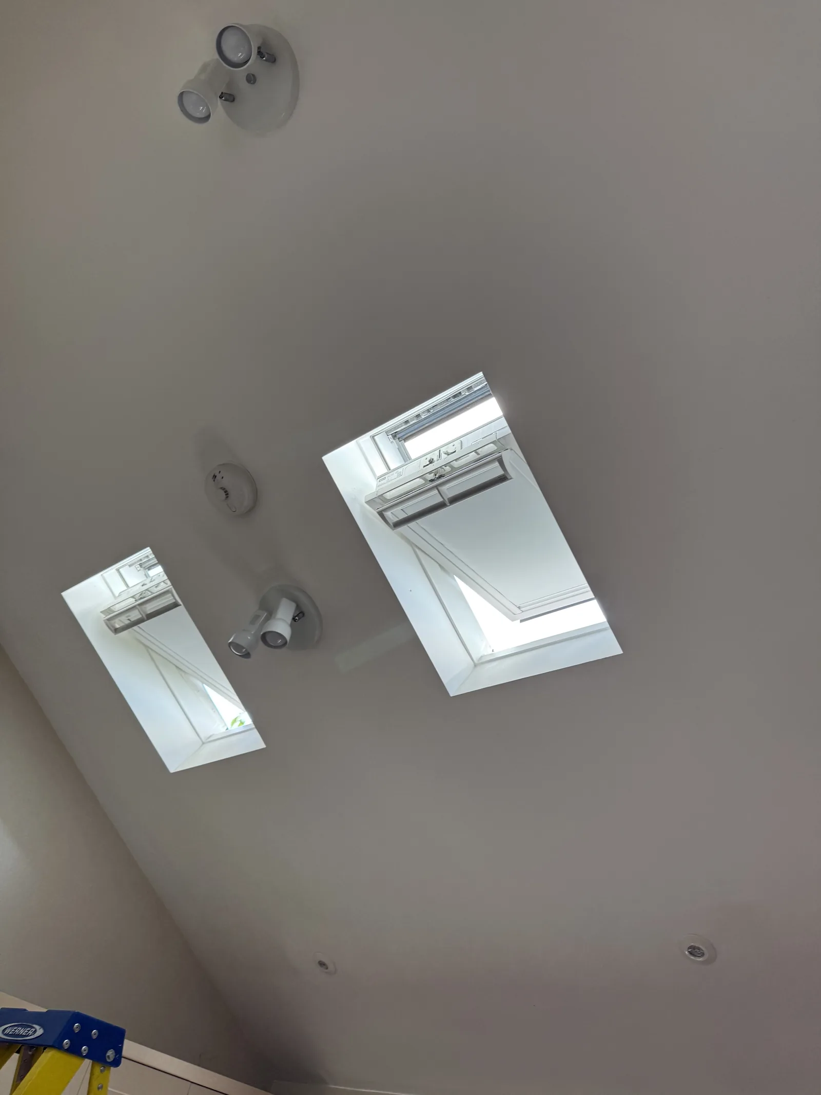 Two roof windows set in a white ceiling