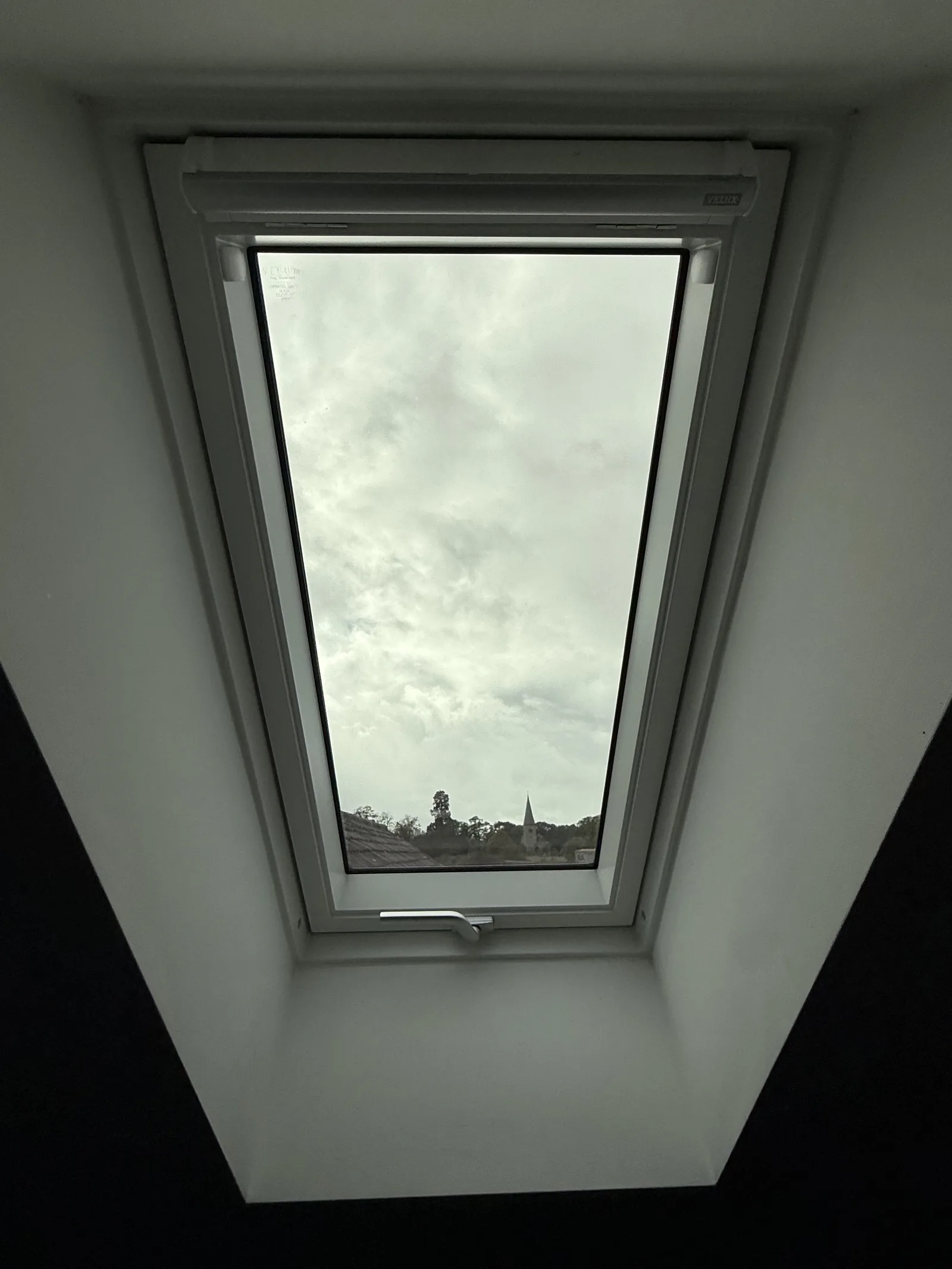 Roof window with a dark interior surround